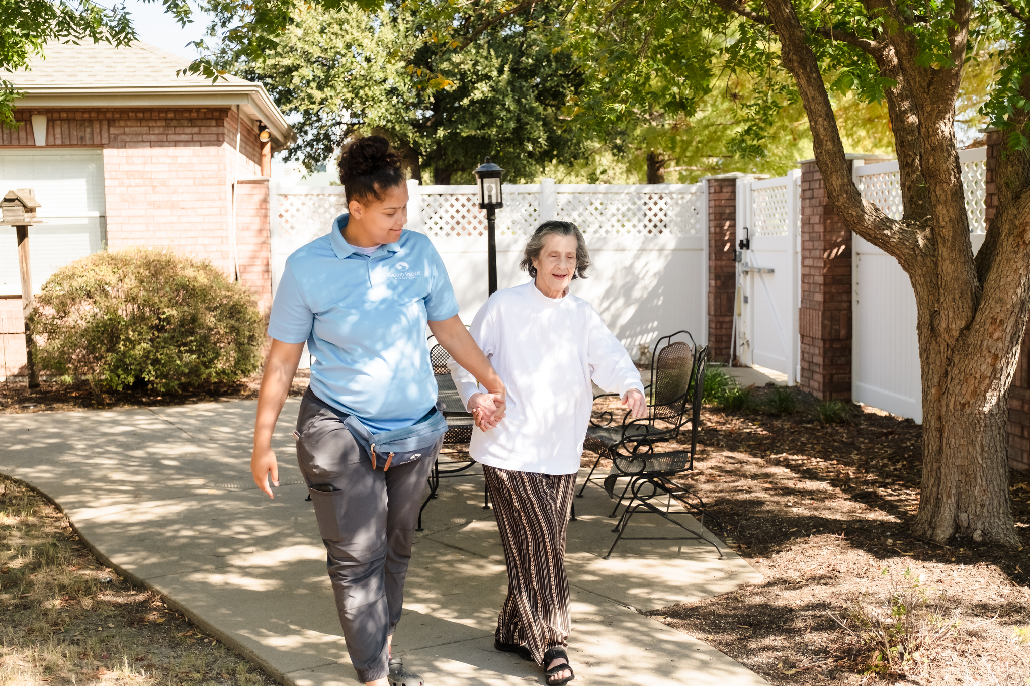 Care giver and resident walking at Grand Brook