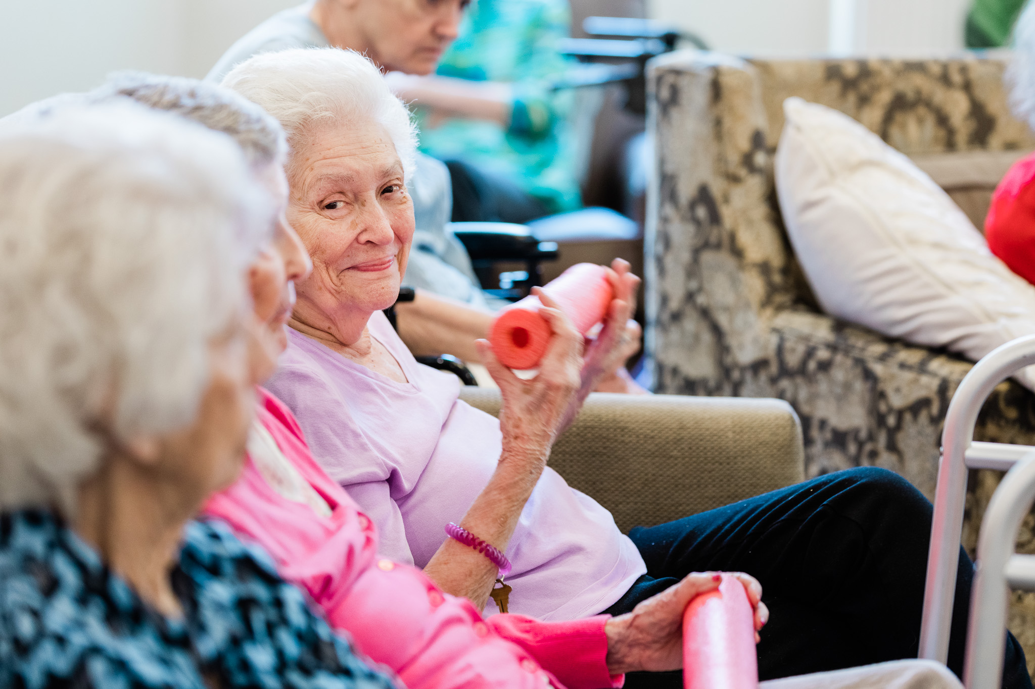 Residents of Grand Brook Memory Care socialising while engaging in light exercise.