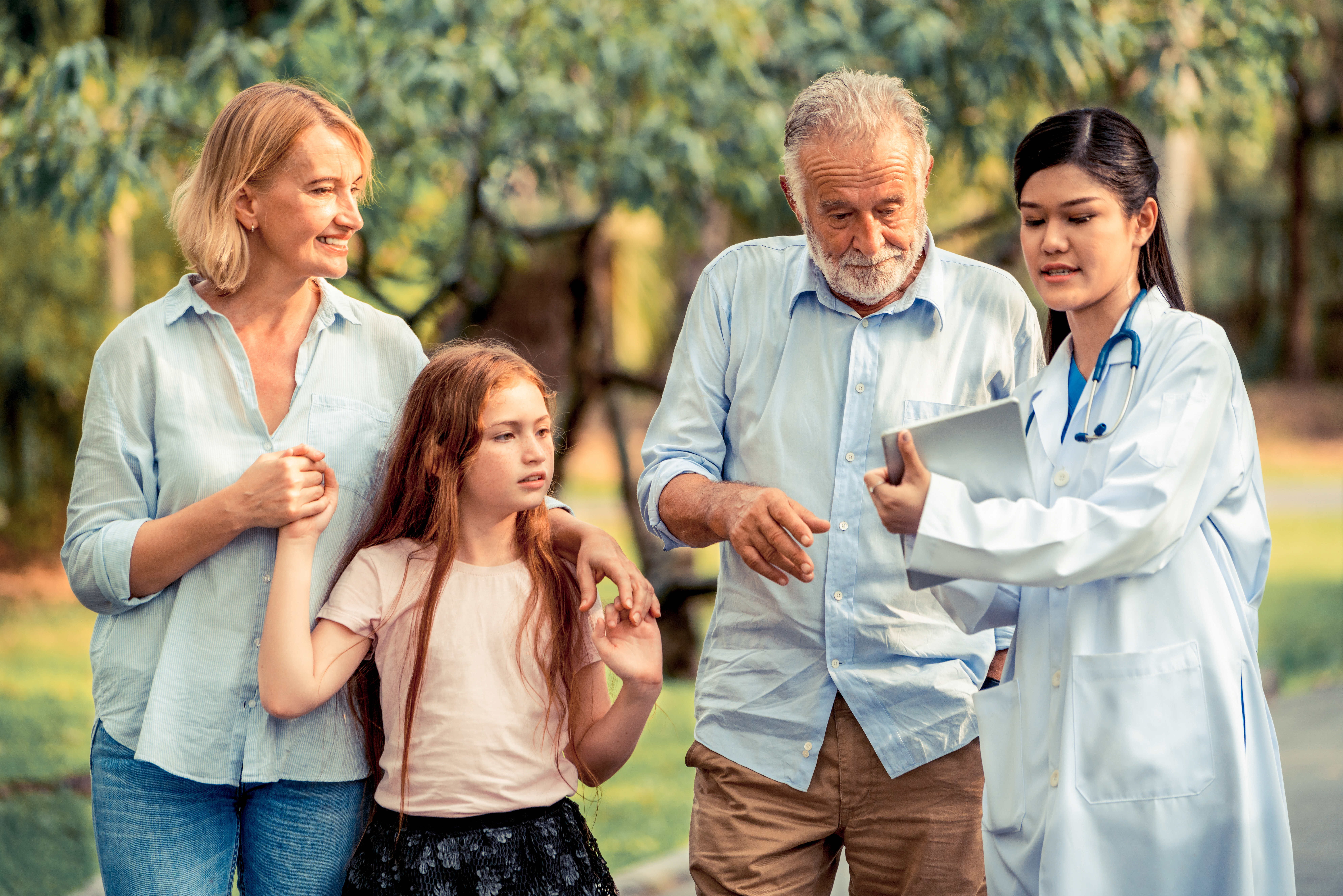 Happy healthy family and doctor talking in the park. People healthcare and medical staff service concept. The doctor is talking about the importance of medication management