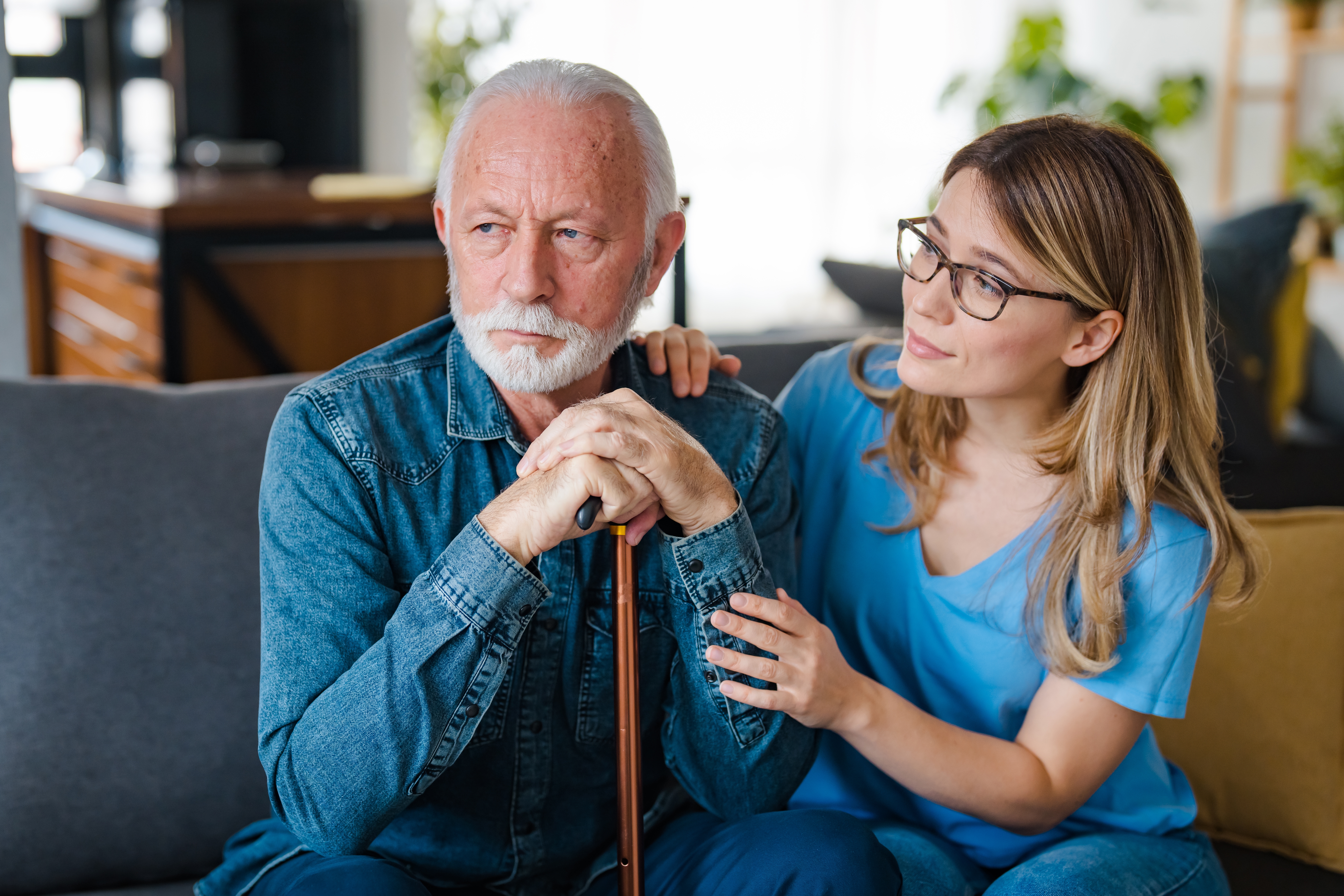 Nurse Visits Senior Man Suffering With Dementia. A woman carer concerned about an elderly man in memory care.