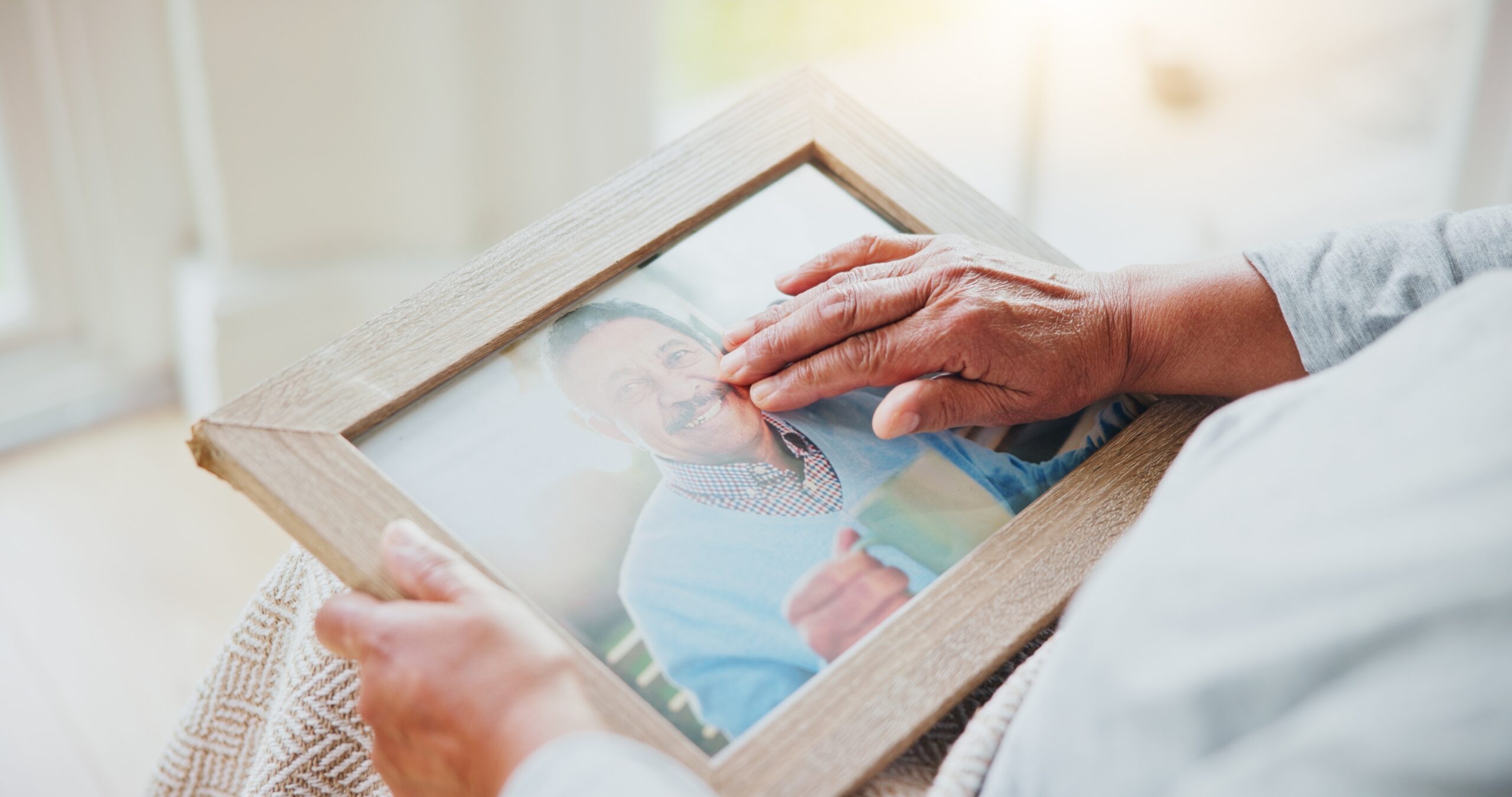 Elderly woman looking at a photo as she has dementia and needs memory care.