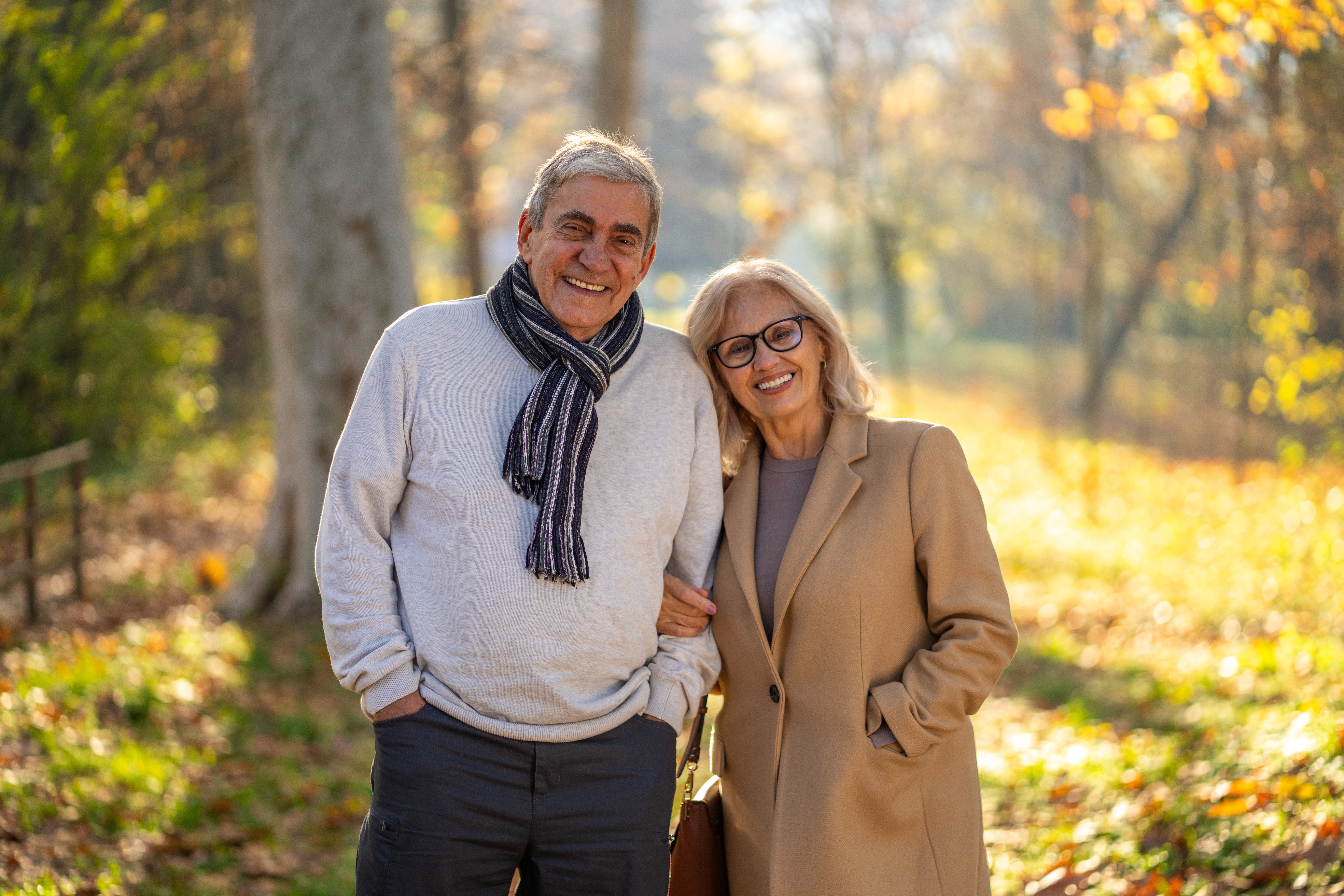 Happy senior couple enjoying a walk in the park during the autumn season
